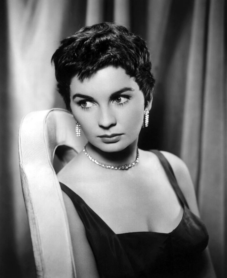 a black and white photo of a woman with short hair wearing a strap around her neck