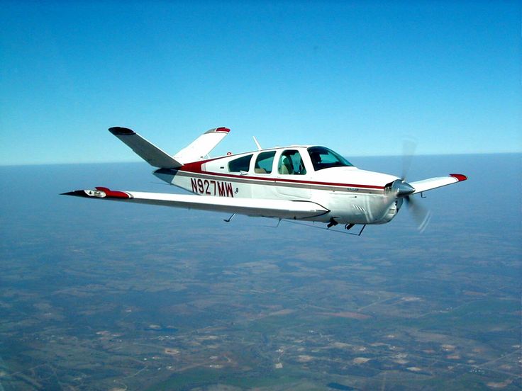 an airplane flying in the air with its landing gear down