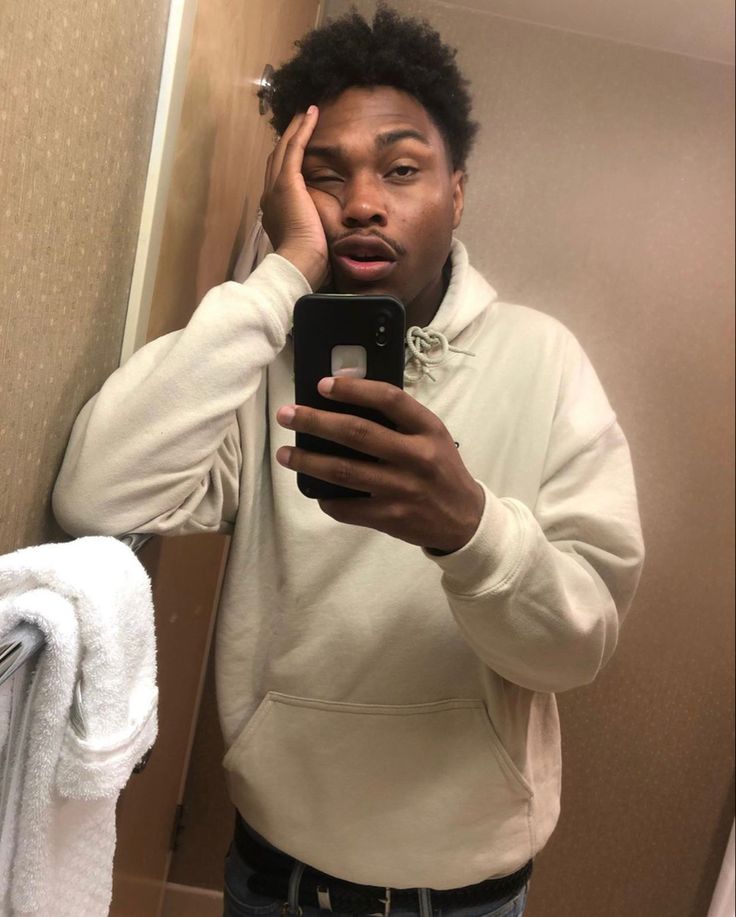 a young man is taking a selfie in the bathroom mirror with his cell phone