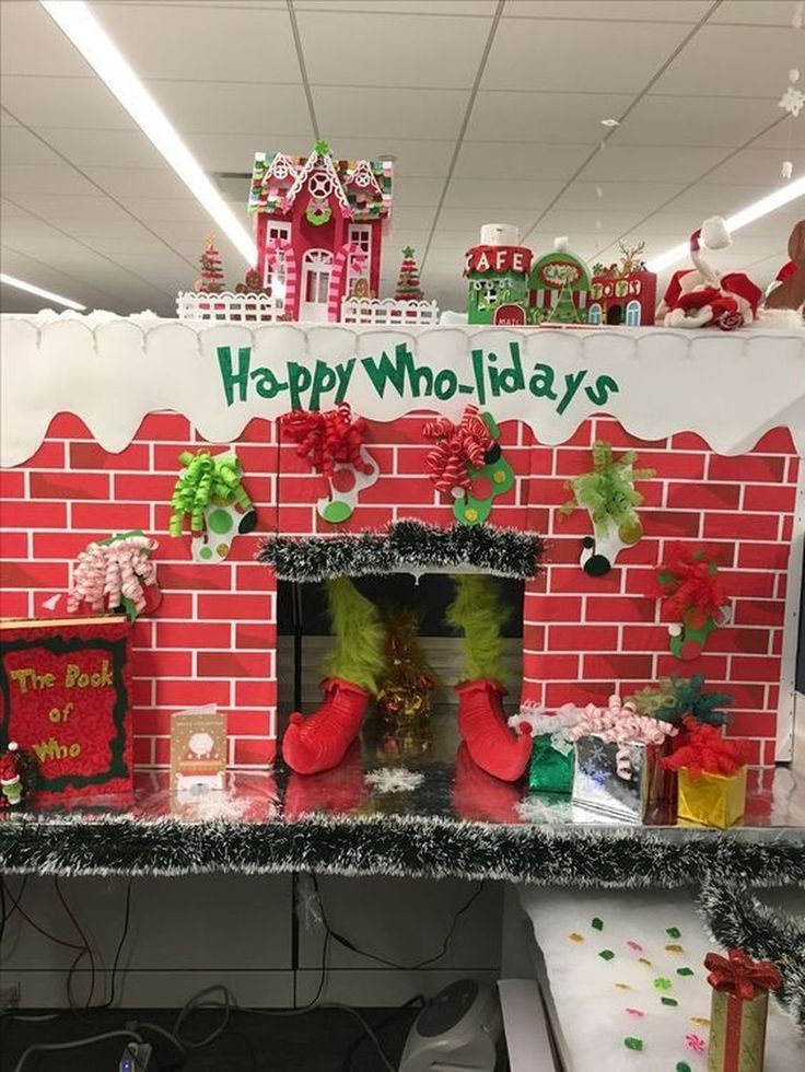 an office cubicle decorated for christmas with decorations on the fireplace and presents under it