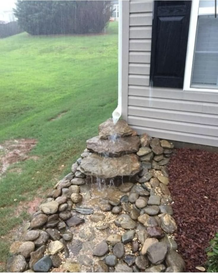 a rock waterfall in front of a house