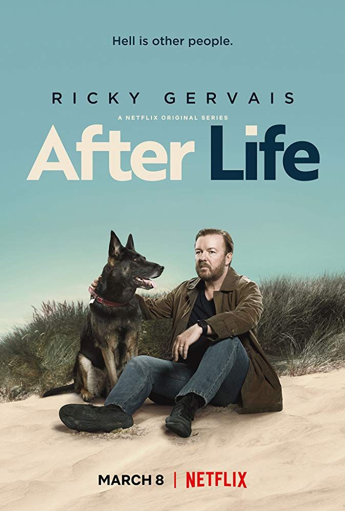 a man sitting next to a dog on top of a sandy beach