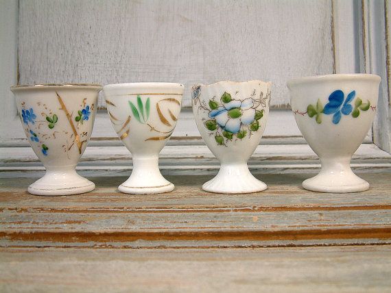 four white vases sitting on top of a window sill next to each other