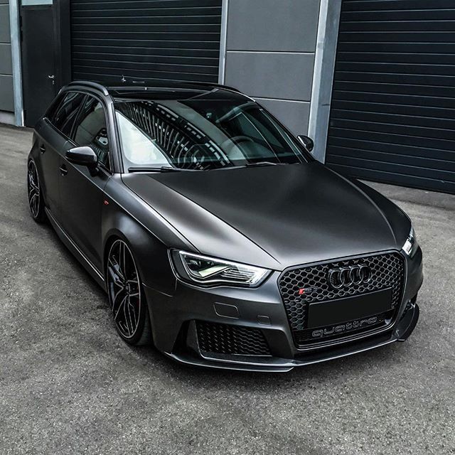 a black car parked in front of a garage