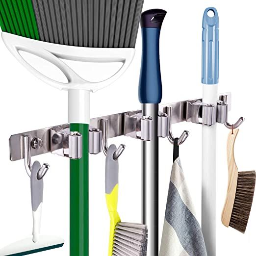 three different types of cleaning brushes hanging from hooks on a wall with towel holders attached to it