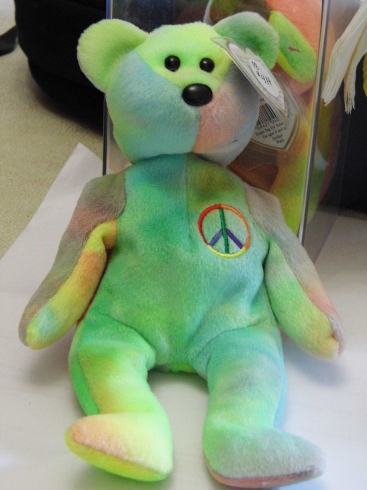 a green teddy bear with peace sign on it