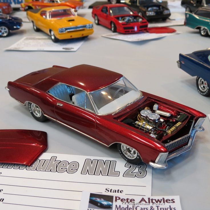 a bunch of toy cars on display in a room with papers and tags around them