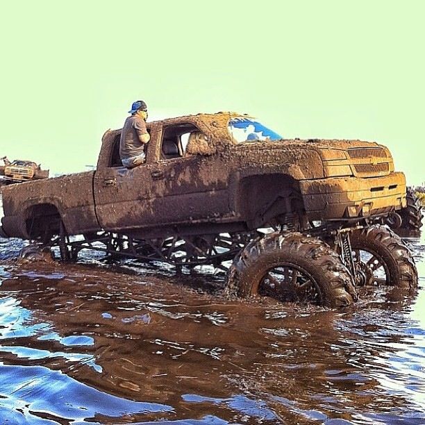 an old pick up truck in the water with two men sitting on it's bed