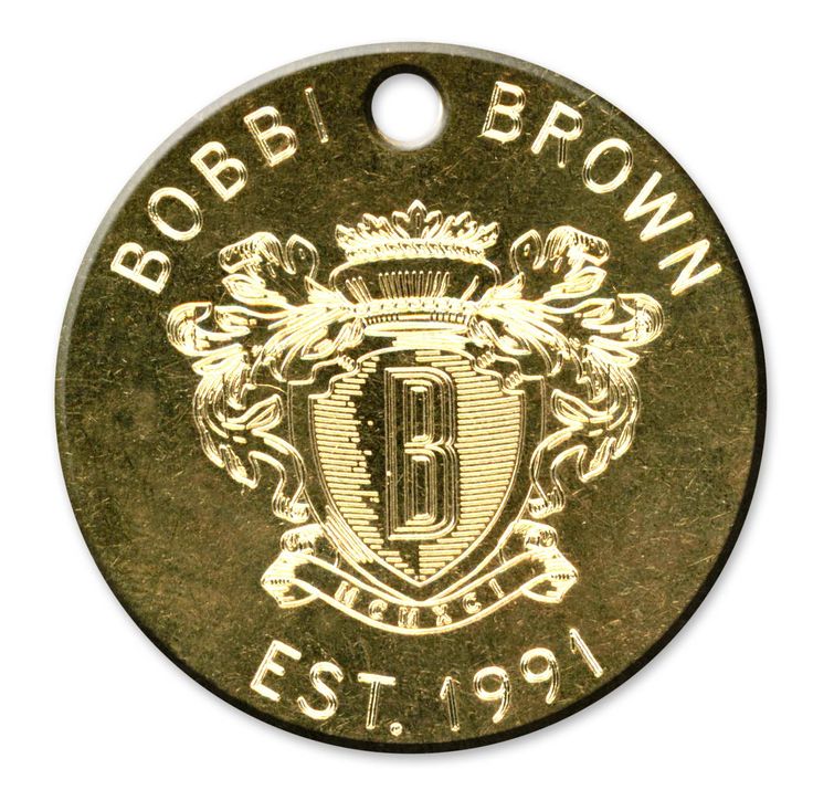 a brown and white dog tag with the letter b on it's front side