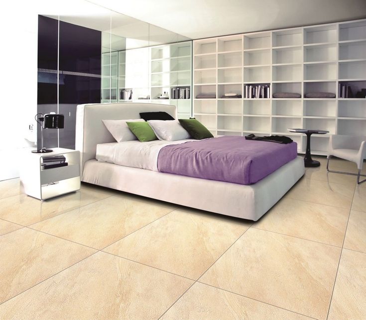 a bedroom with white and purple bedding, bookshelves, and mirrored walls