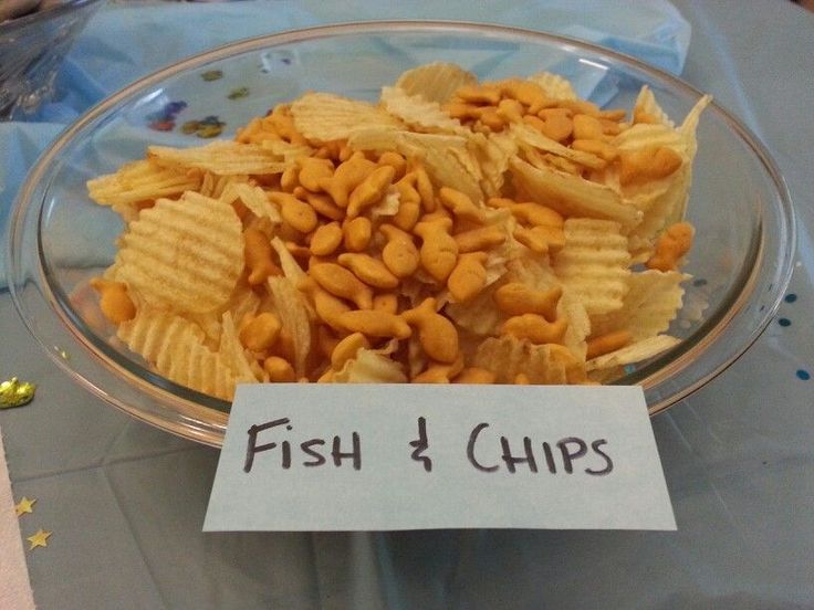 a bowl filled with fish and chips next to a sign that says fish and chips