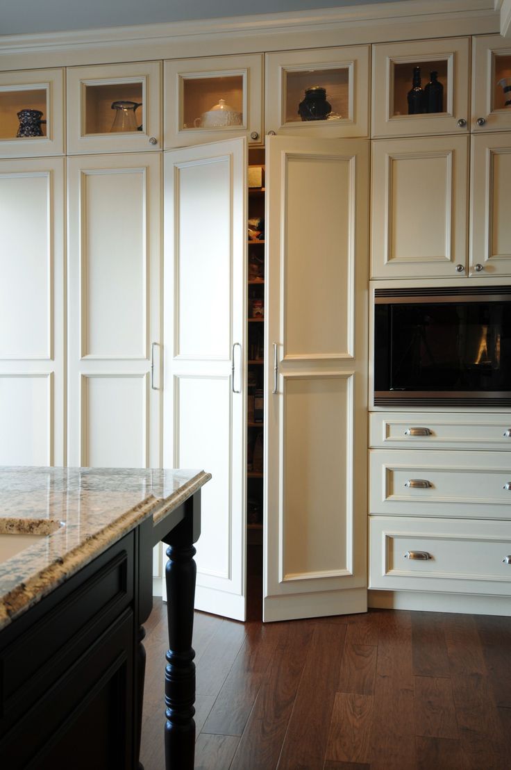 a kitchen with white cabinets and marble counter tops