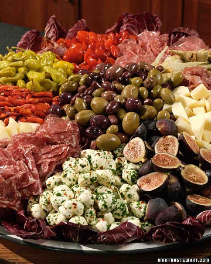 an assortment of olives, artichokes, and meats on display