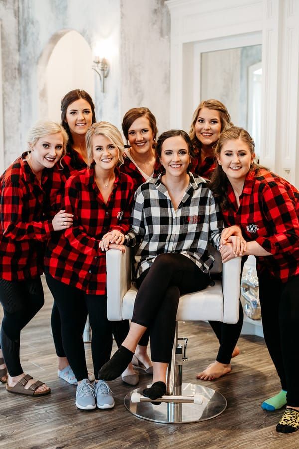 a group of women in red and black flannel shirts posing for a photo