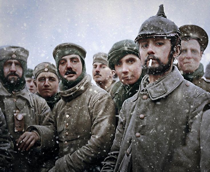 a group of men in uniforms standing next to each other with snow falling on them