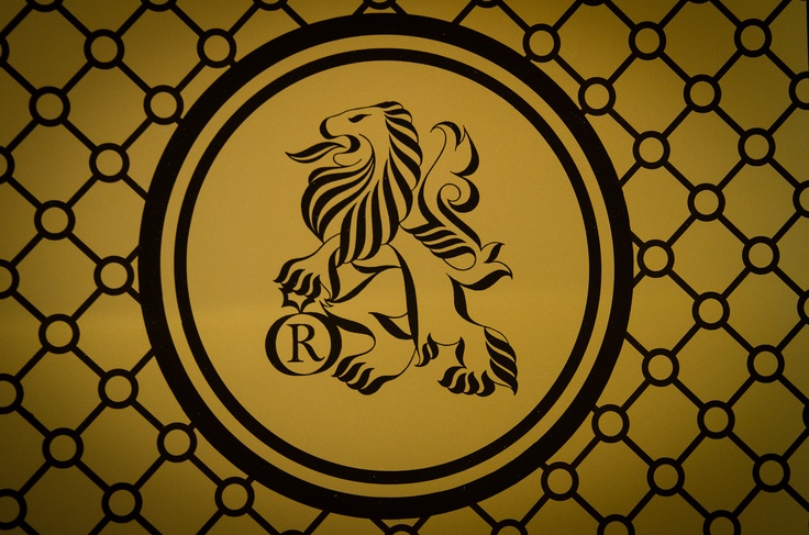 a lion emblem on the side of a wall in a room with geometric patterns and circles