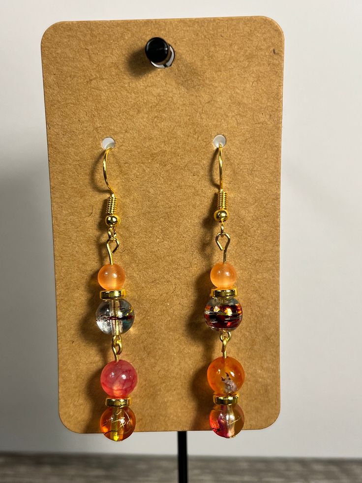 Handmade Earrings - Colors Series Each piece is meticulously handcrafted using craft wire, hypoallergenic earring hooks, and premium beads including crystal, glass, wood, ceramic, acrylic, resin, stone, and silicone beads. Care Instructions: Avoid moisture. Remove prior to bathing, showering, swimming, or exercising. Avoid allowing the item to fold when storing.  Shipping Information: Your items will be shipped within 1-2 business days once payment is received. Shipping within the US is via first class mail or you may choose to upgrade to Priority Mail for a small fee. Each item is carefully wrapped and packaged for safety during transit. Returns & Exchanges: As this is a wearable item, I do not accept returns or exchanges on this item. All sales are final. If there is a problem once your Orange Glass Beaded Jewelry, Glass Beaded Earrings With Dangling Beads, Glass Beaded Earrings For Gift, Gold Wire Wrapped Glass Earrings, Glass Drop Crystal Earrings For Gift, Resin Drop Earrings With Ear Wire, Glass Beaded Dangle Earrings For Gift, Adjustable Czech Glass Earrings With Ear Wire, Handmade Amber Round Bead Earrings