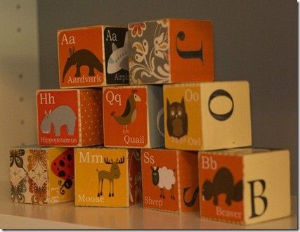 wooden blocks with animals and letters on them sitting on a table in front of a mirror