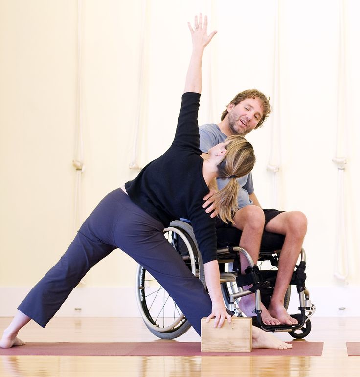 a man in a wheel chair and a woman doing yoga