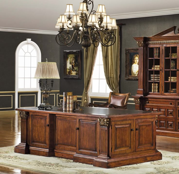 an office desk with a chandelier hanging from the ceiling