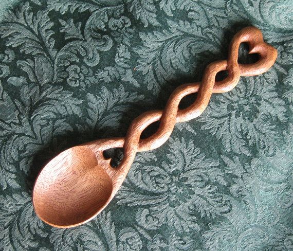 a wooden spoon sitting on top of a green tablecloth covered floor next to a wall