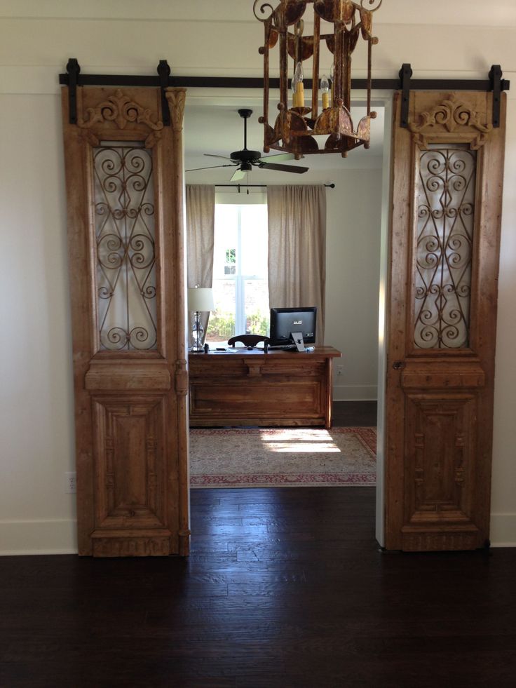 an open door leading to a living room with a chandelier hanging from the ceiling