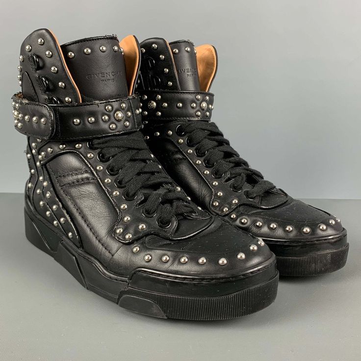 Givenchy High Top Sneakers Comes In A Black Leather Featuring A Silver Studded Details, Rubber Sole, And A Lace Up Style. Very Good Pre-Owned Condition. Light Wear. As-Is. Marked: 42 Measurements: Length: 11.5 Inches Width: 4.25 Inches Height: 8 Inches Sui Generis Reference: 124998 Category: Sneakers More Details Brand: Givenchy Size: 9 Gender: Male Color: Black Pattern: Studded Fabric: Leather Style: High Top Condition: As Is Age Group: Adult Sui Generis Designer Consignment Is An Award Winning Calf Leather High-top Sneakers With Studded Outsoles, Leather High-top Sneakers With Perforations, Leather High-top Sneakers With Perforations And Round Toe, High-top Leather Sneakers With Spikes, Edgy Leather High-top Sneakers With Studded Outsoles, Black Leather High-top Sneakers With Perforations, Edgy Leather High-top Sneakers, Leather Sneakers With Studded Rubber Outsoles, Edgy Leather Lace-up Sneakers