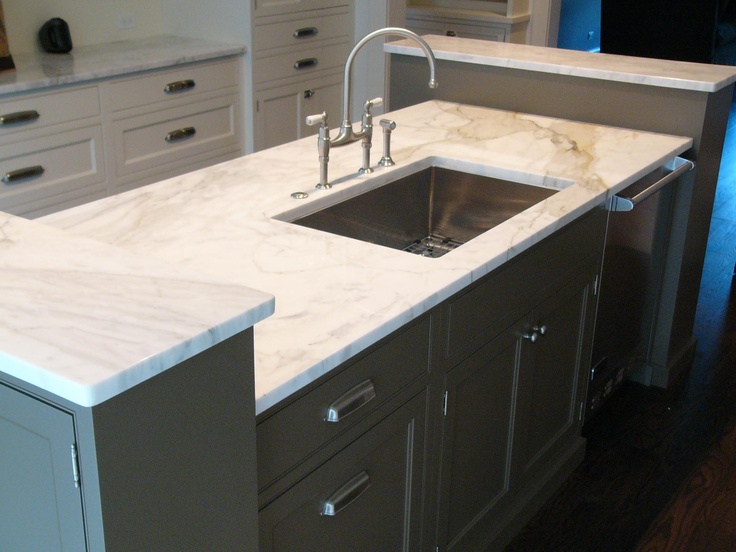 a kitchen with marble counter tops and stainless steel sink faucets in the center