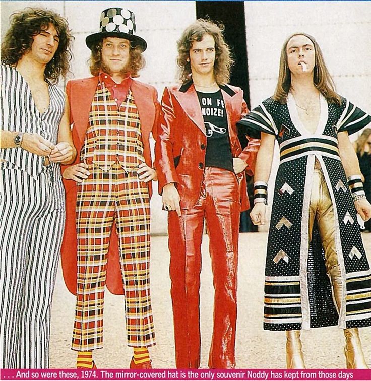 three men in colorful outfits standing next to each other and one man with long hair