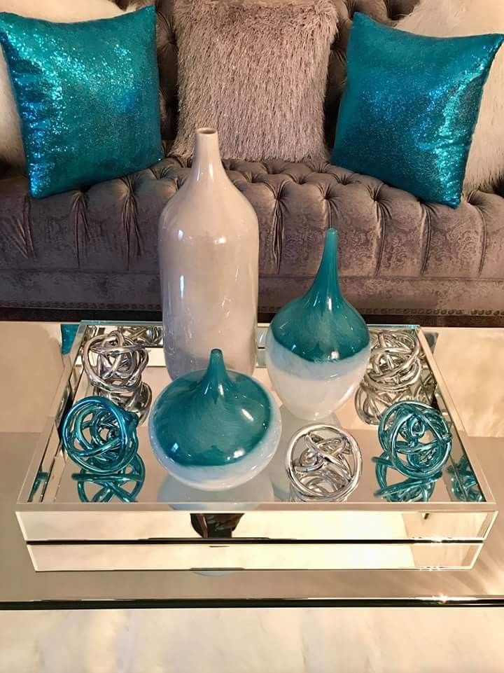 a coffee table with two vases on it and some other items in the tray