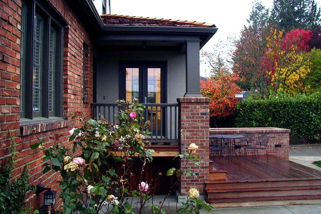 a house with a deck and flowers in the front yard