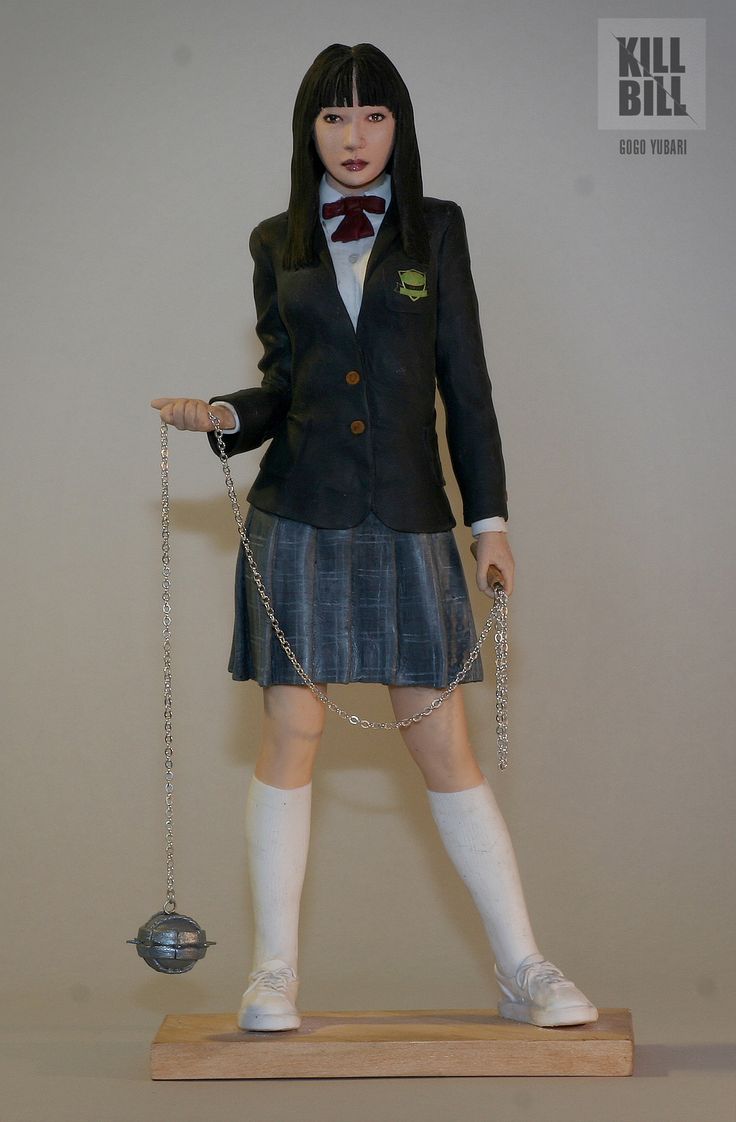 a statue of a girl in a school uniform holding a scale with a chain attached to it