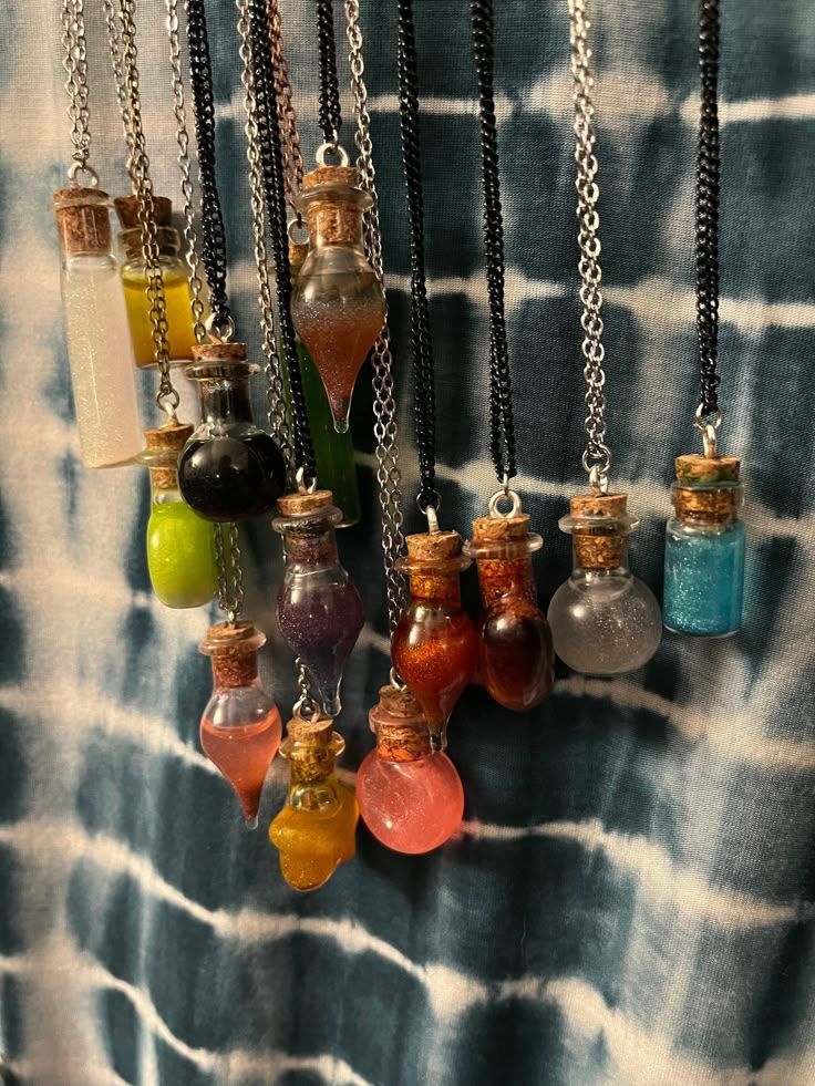 Create your own sparkly magical potion bottle necklace! Each necklace is handmade and unique to each creator. Magic is all around us, and can be used in any number of ways. Colors can be a great way to manifest and attract the energies you want to surround yourself with. These magical bottles are a fantastic addition to any outfit, cosplay or costume! These necklaces also make great fidget toys with the color shifting liquid inside. Each order is for one customized bottle and chain! Spell Bottle Necklaces, Mini Bottles Necklace, Cheap Metal Necklaces For Cosplay, Goblincore Crafts Necklaces, Mini Glass Bottle Necklace, Witch Potion Necklace, Ren Faire Necklace, Antique Bottle Jewelry, Flower Bottle Necklace