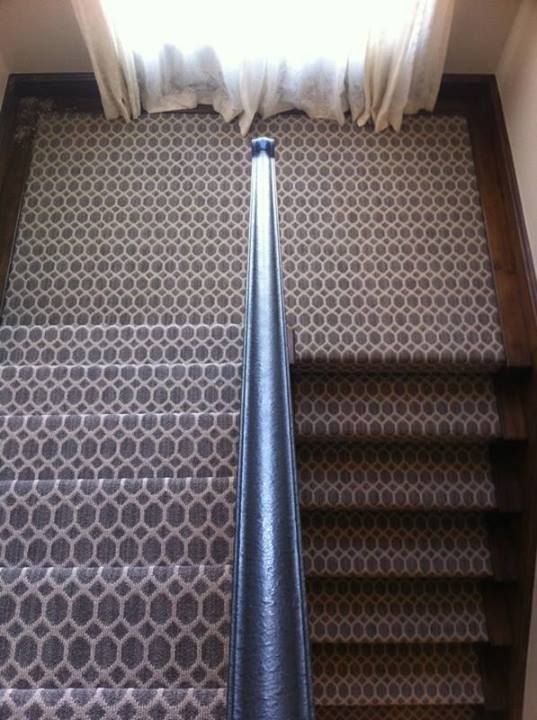 an overhead view of a carpeted stair case with a window in the back ground