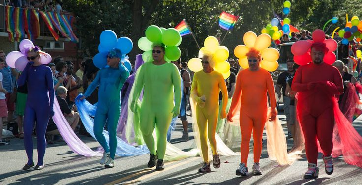 several people in colorful costumes walking down the street