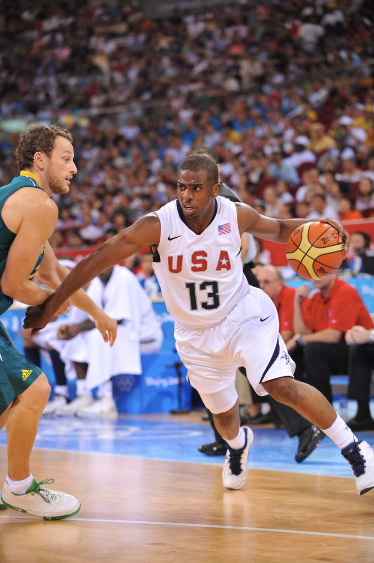 two men are playing basketball in front of an audience