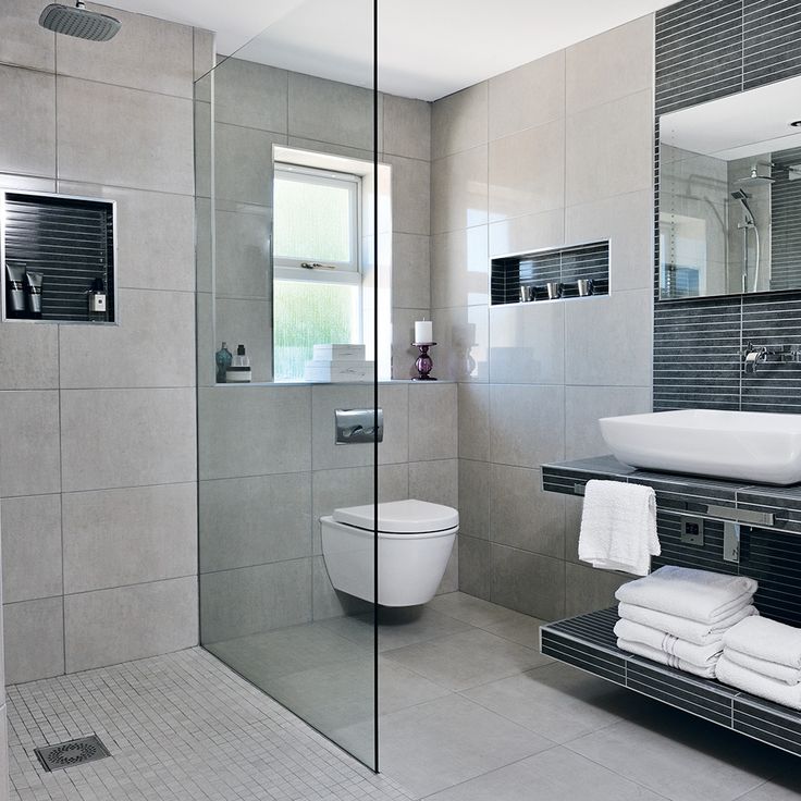 a bathroom with a glass shower door, toilet and sink