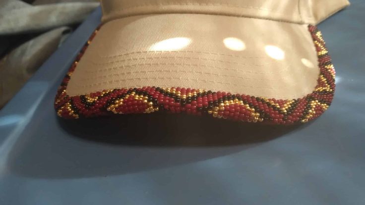 Custom Beaded hat in red gold and black geometric design.
Tan snapback hat. Leather Jewelry Making, Beaded Ball, Beaded Hat, Cap Patterns, My Community, Silver Wolf, Wolf Design, Ball Caps, Handmade Hat