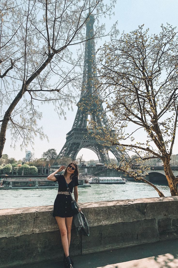 A girl in a black dress and black boots smiles in front of the Eiffel Tower in Paris Eiffel Tower Instagram, Eiffel Tower Picture Ideas, Paris Picture Ideas, Eiffel Tower Pictures, Paris Instagram Pictures, Paris Photo Ideas, Girl In Paris, Eiffel Tower Photography, Spots In Paris