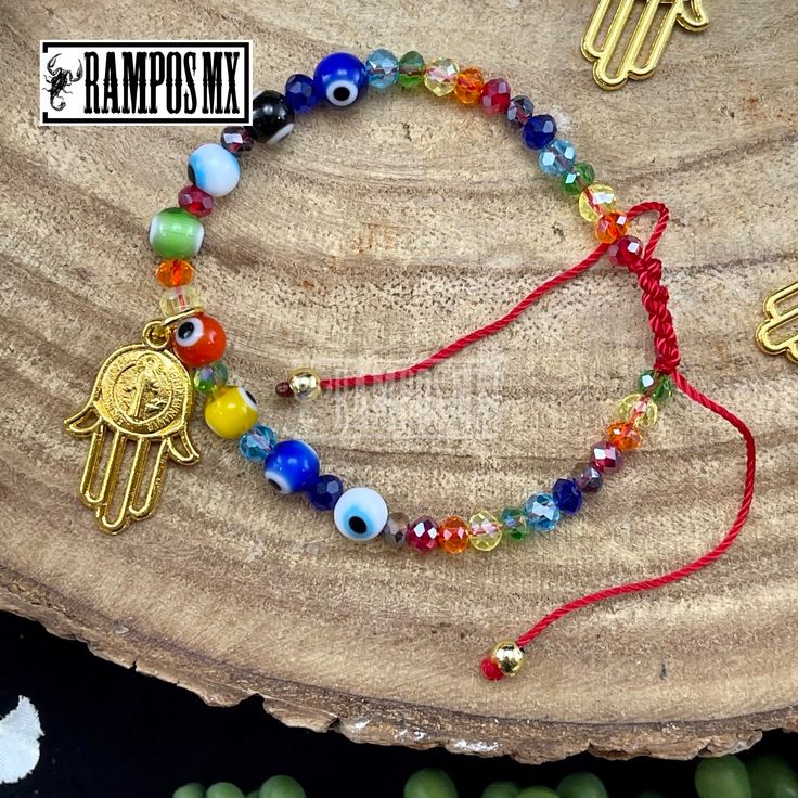 the hamsah bracelet is decorated with colorful beads and evil eye charms, as well as an egyptian symbol