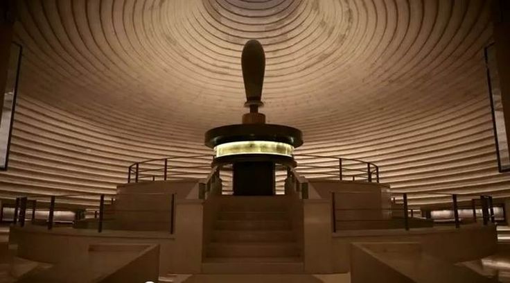 a large room with stairs leading up to the ceiling and lights in the center on either side