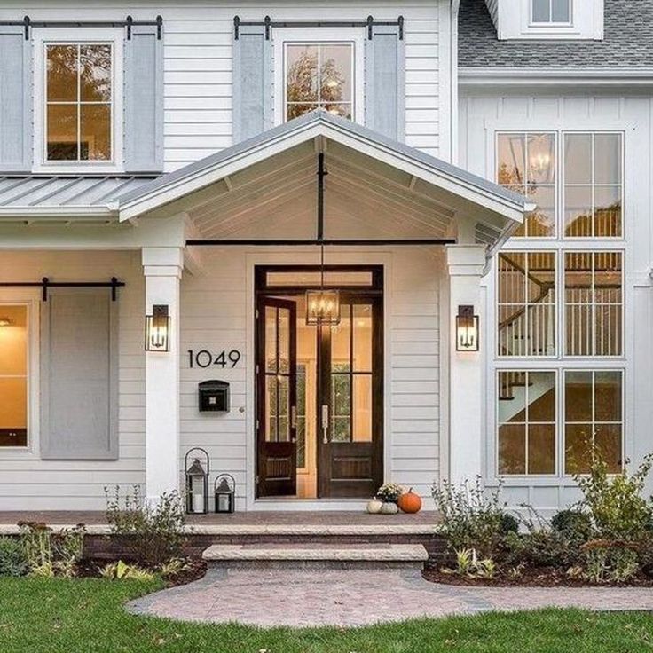 a white house with lots of windows and steps leading up to the front door area