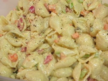 a bowl filled with macaroni salad sitting on top of a table