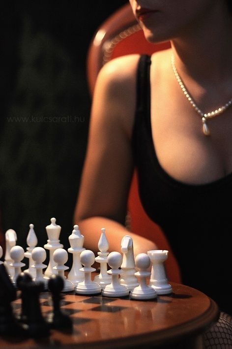 a woman sitting at a table playing chess