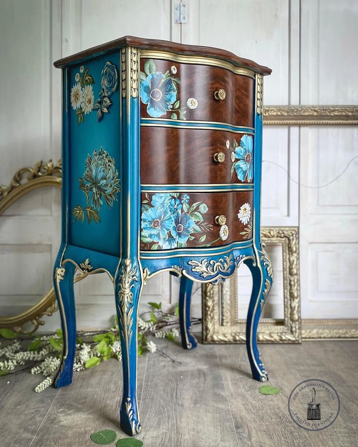 a blue and brown dresser with flowers painted on it