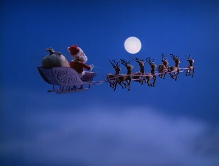 santa's sleigh with reindeers flying in the sky at night time