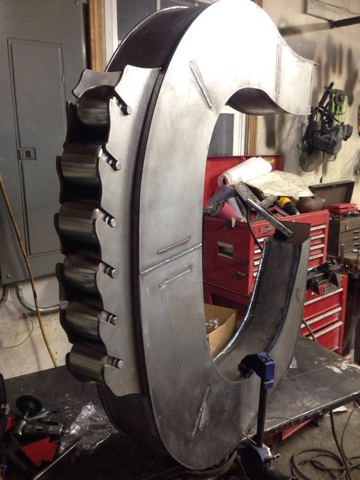 a large metal object sitting on top of a workbench in a garage with lots of tools