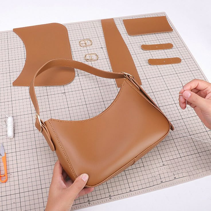 someone is making a purse out of leather