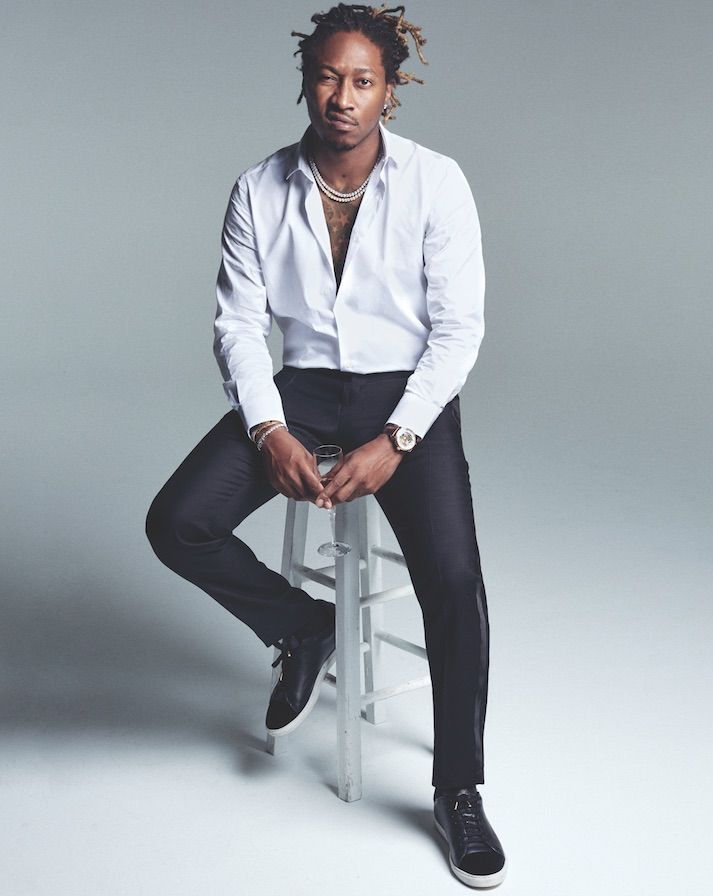 a man with dreadlocks sitting on a stool