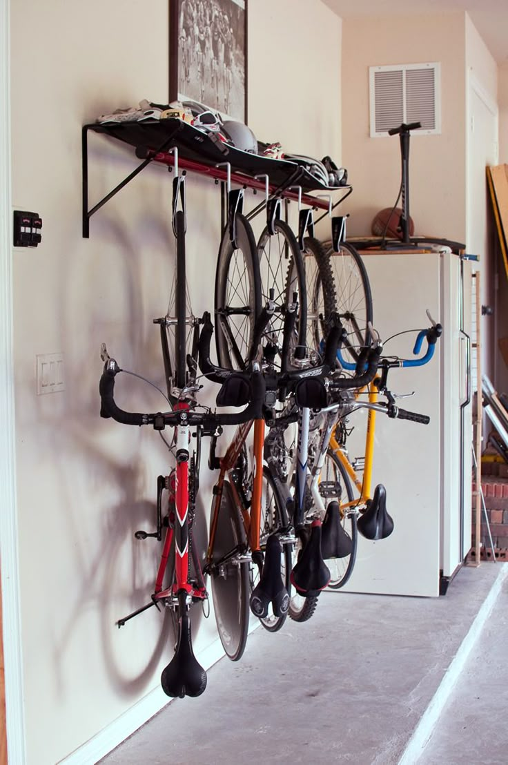 there is a bike hanging on the wall next to some racks with bikes in it